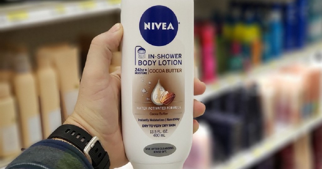 hand holding bottle of cocoa butter in shower body lotion in store