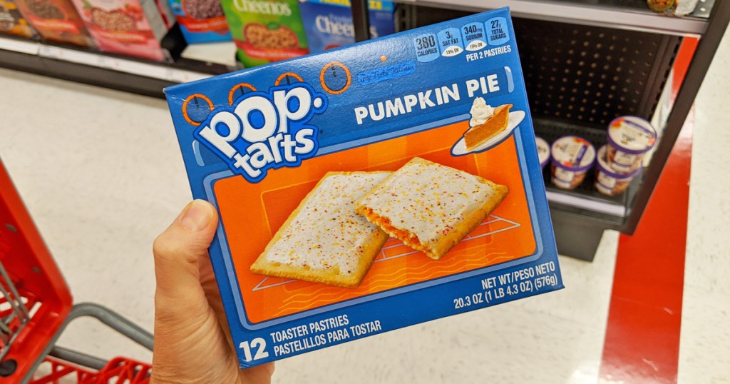 person holding up a blue and orange box of pumpkin pie flavored pop tarts