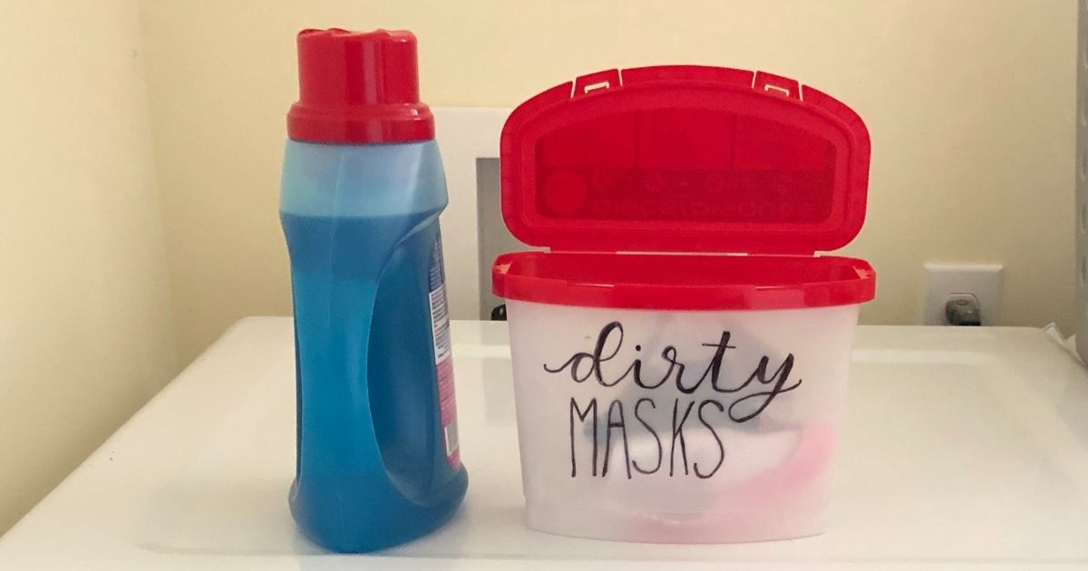 Persil liquid laundry detergent and container with "dirty masks" lettering on top of washer
