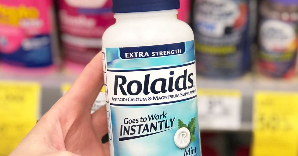 person holding up bottle of mint flavored Rolaids antacid tablets