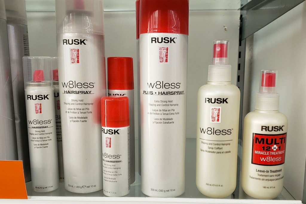 white and red bottles of rusk brand haircare styling products on shelf