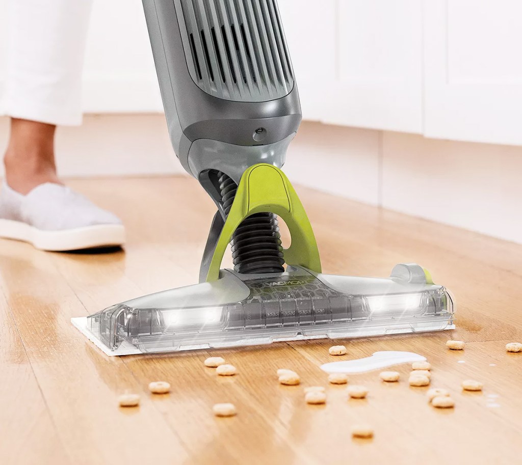 person using a shark vacmop on hardwood floors to clean up spilled milk and cereal