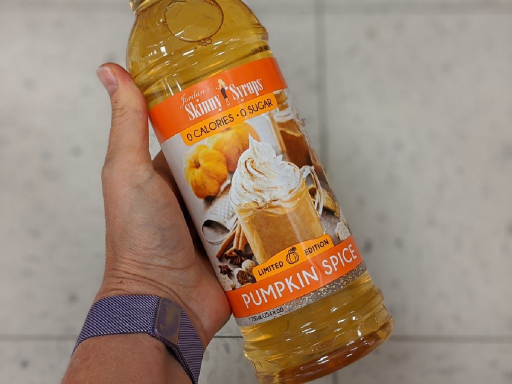 hand holding large bottle of pumpkin spice sugar free syrup