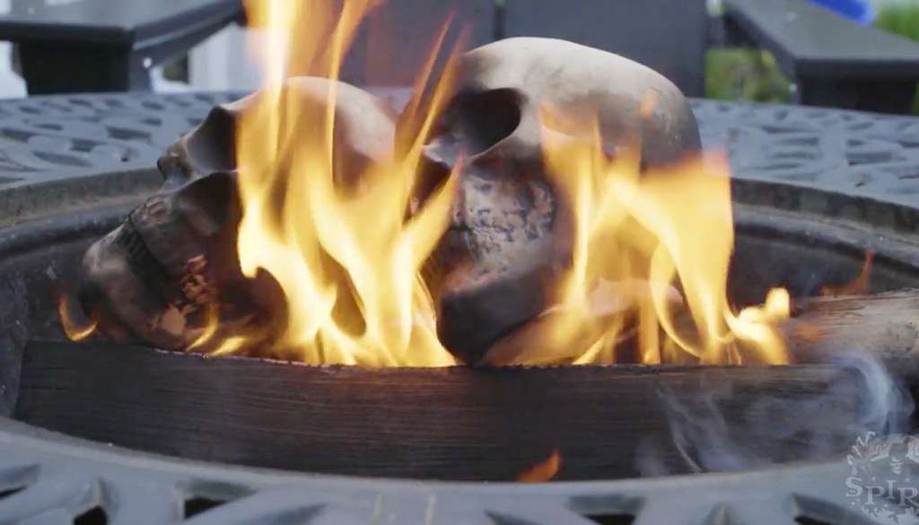 ceramic skulls on fire inside wood fire pit