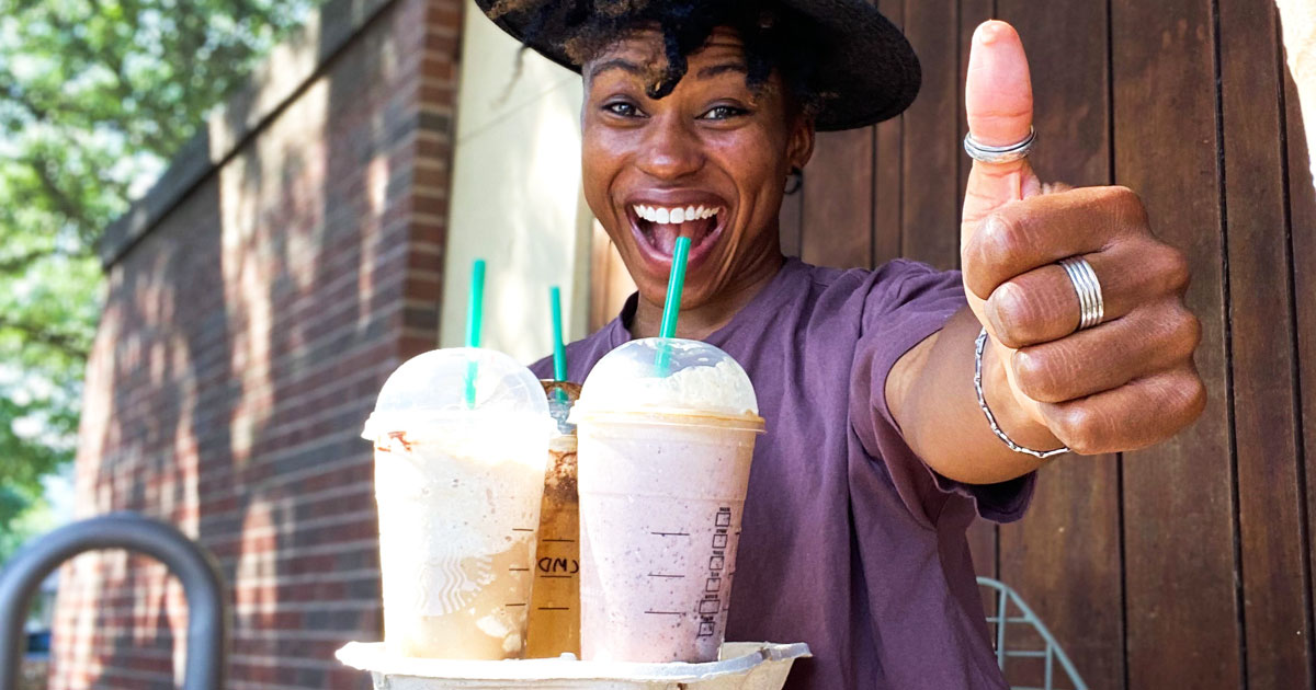 woman holding try of starbucks drinks