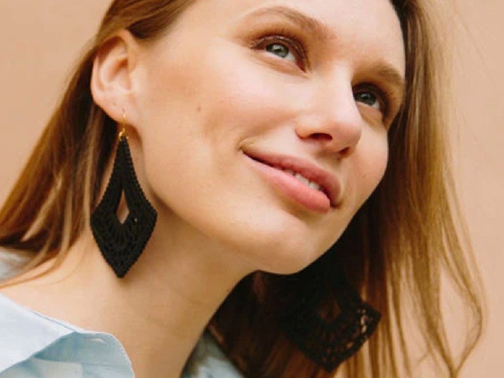 women smiling wearing dark wood dangly earrings