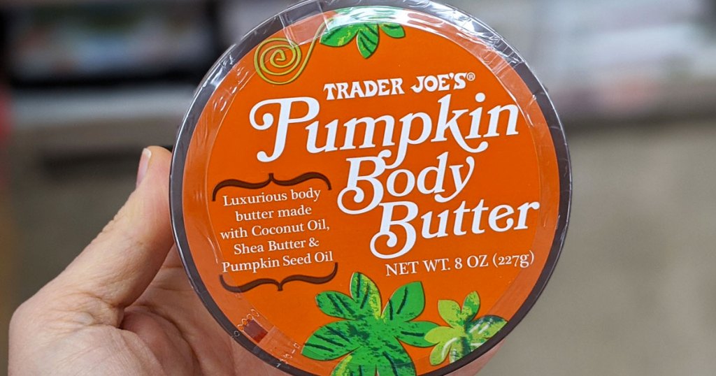 person holding up a round container of pumpkin body butter