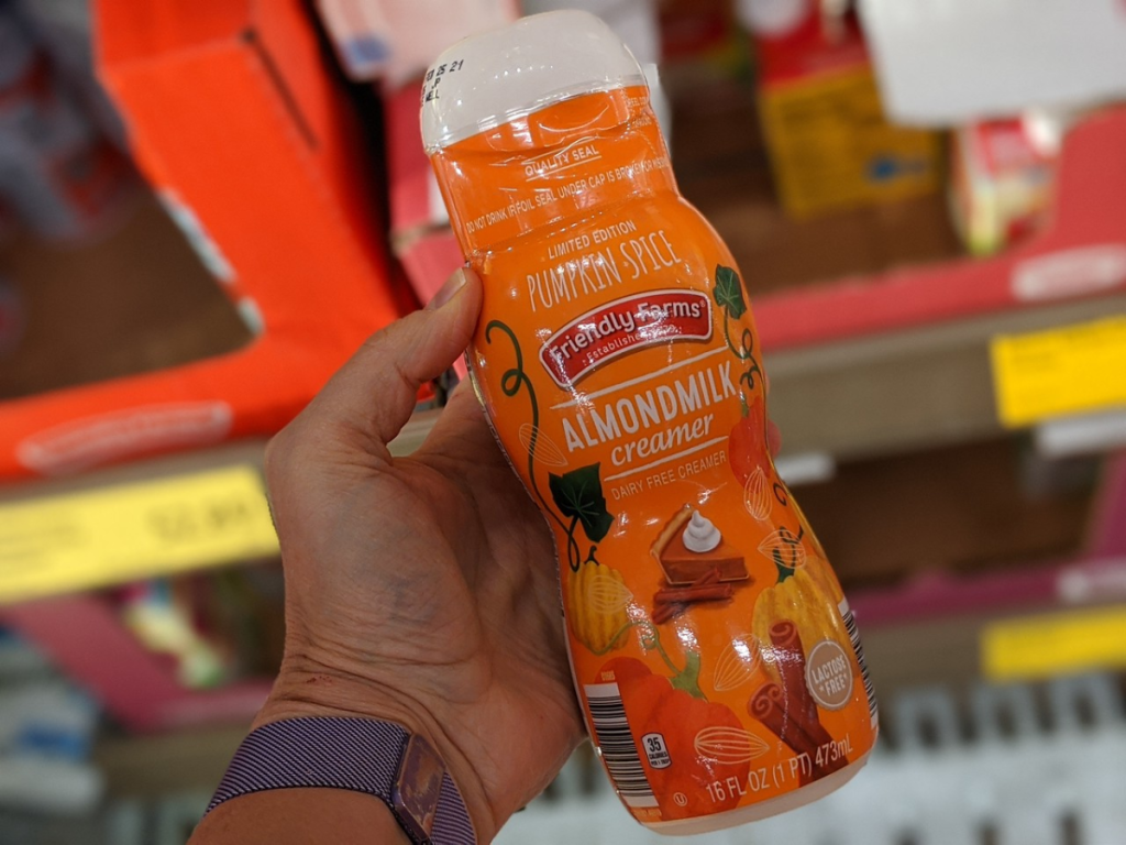hand holding bottle of almond milk creamer with pumpkin spice