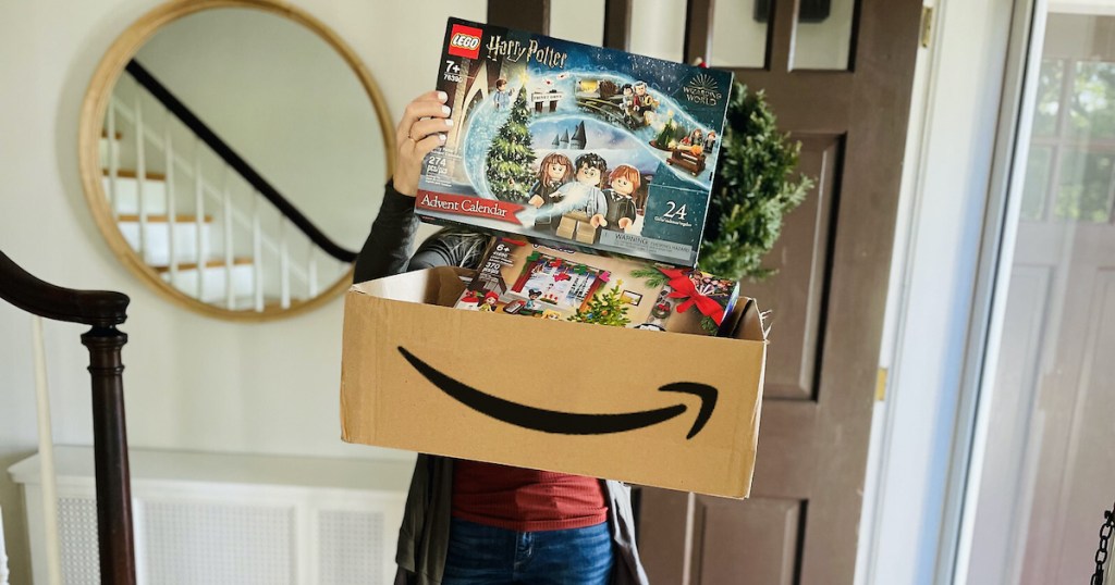 woman holding up amazon box with lego advent calendars inside