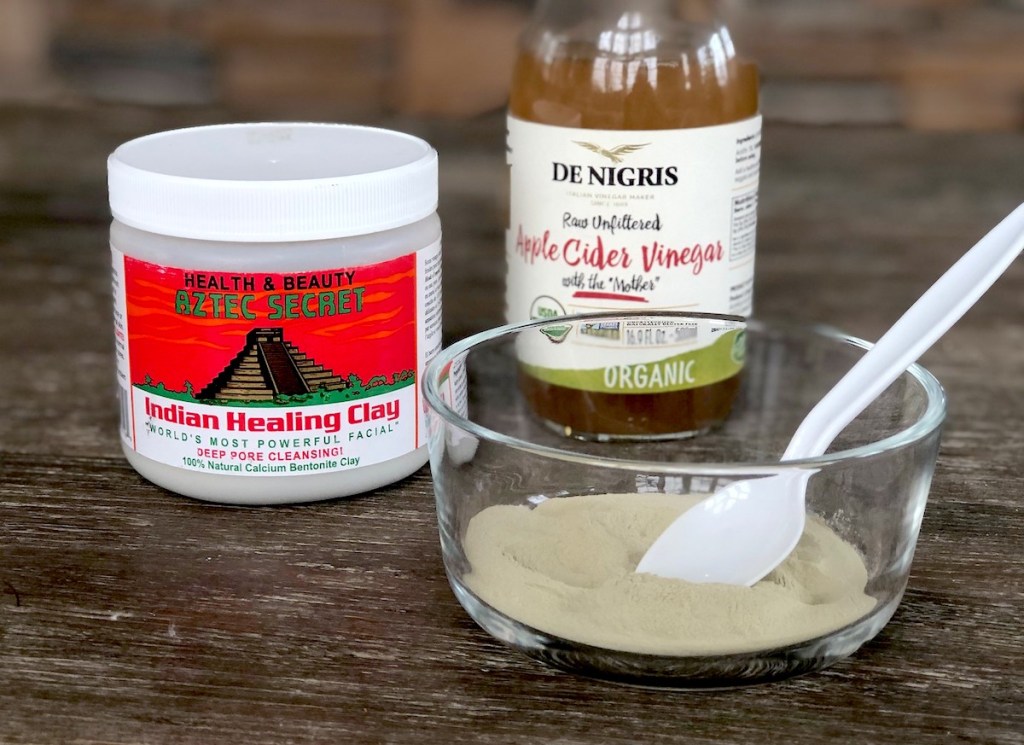 aztec indian healing clay and apple cider vinegar with clear bowl on wood table