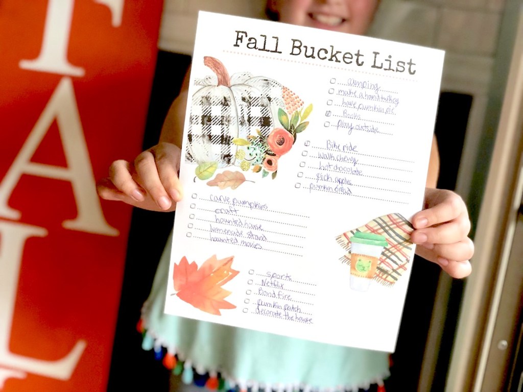 girl holding printable fall bucket list