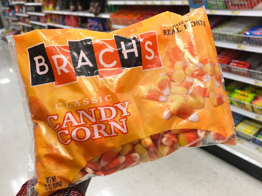 hand holding up big bag of candy corn in store