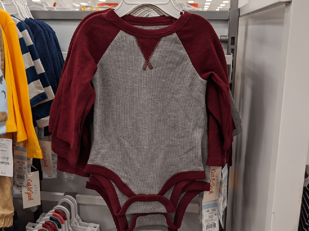 little baby body suit hanging in store display