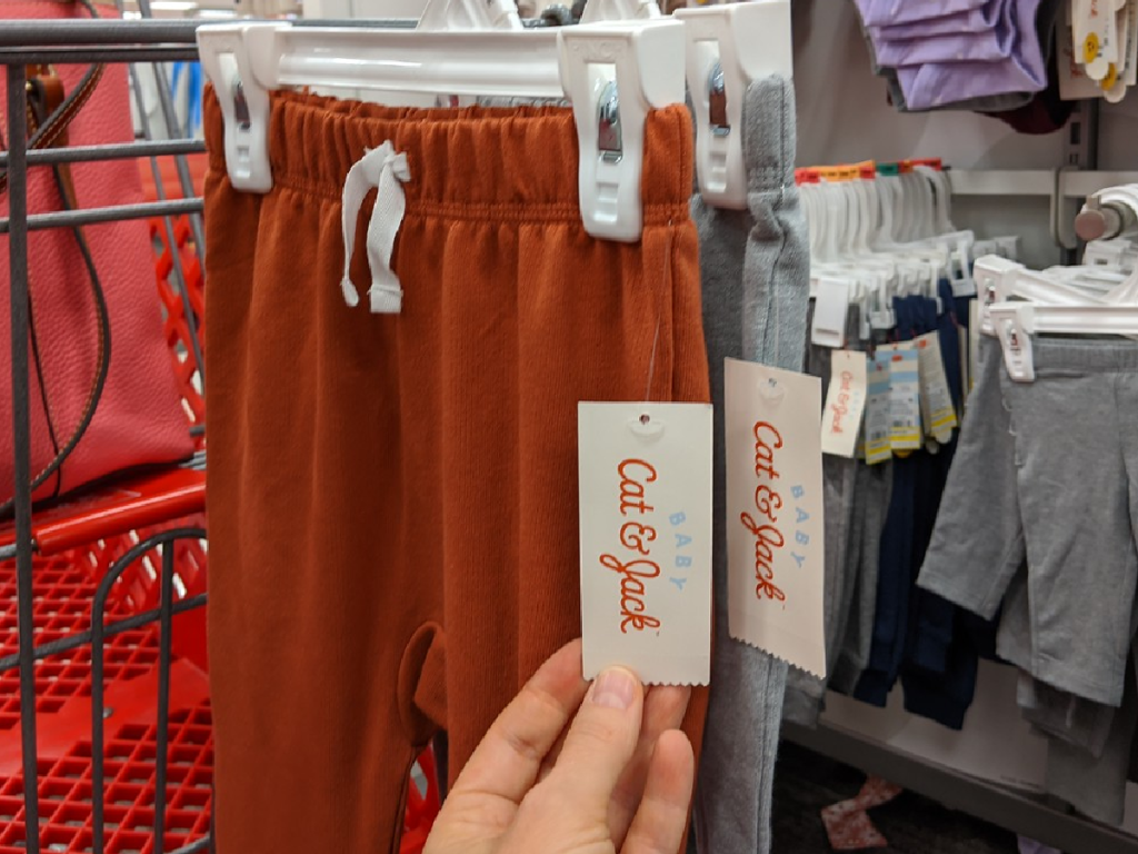 hand showing tag on pair of small pants in store