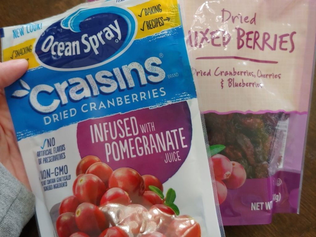 hand holding Ocean Spray Craisins and Dried Mixed Berries bags
