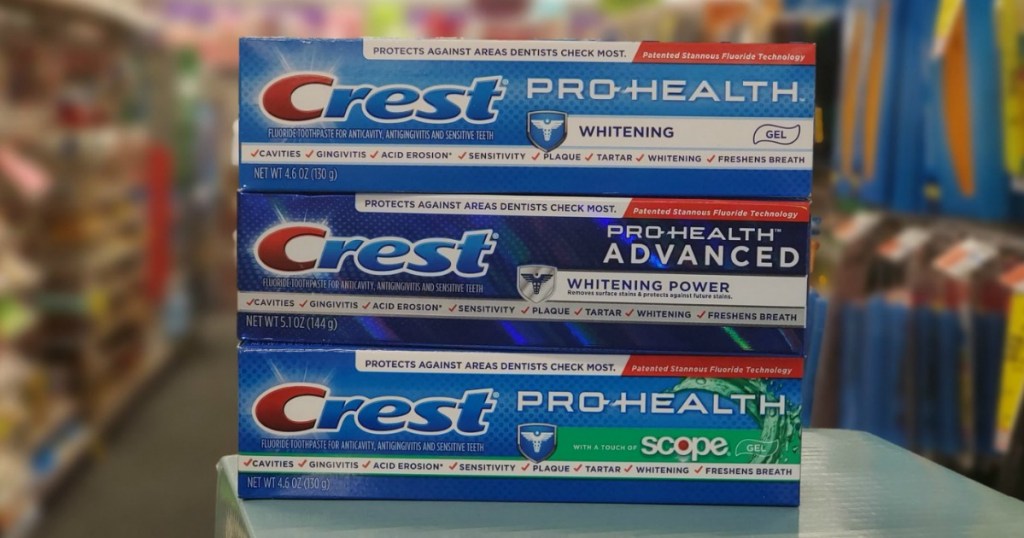 three crest toothpastes stacked on a table in a store