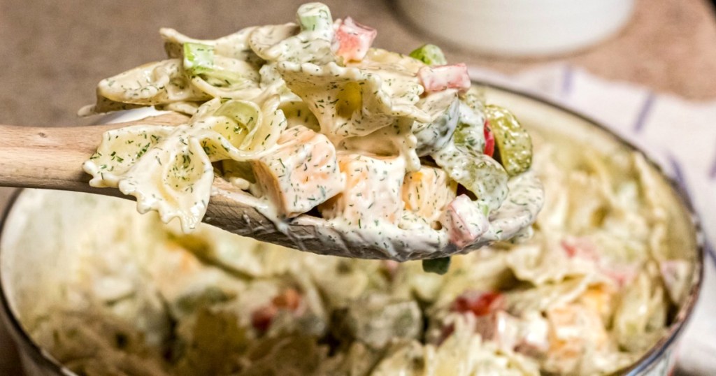 dill pickle pasta salad on wooden spoon