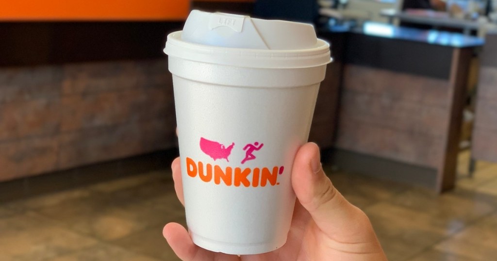 holding a cup of coffee from Dunkin