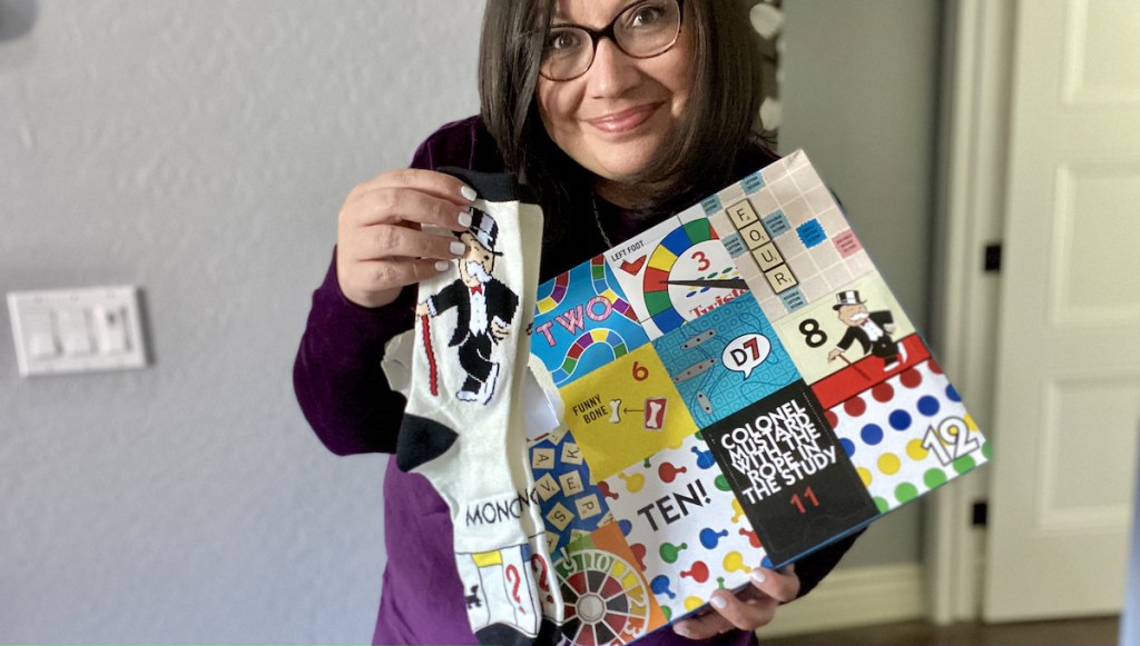 woman holding pair of monopoly socks with board game advent calendar