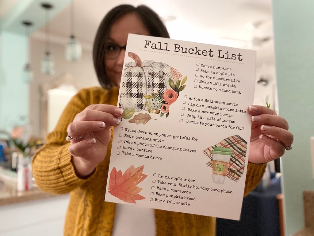 woman holding Fall Bucket List printable 