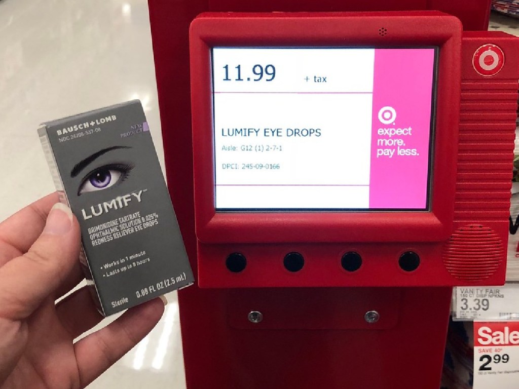 hand holding box with eye drops next to price scanner