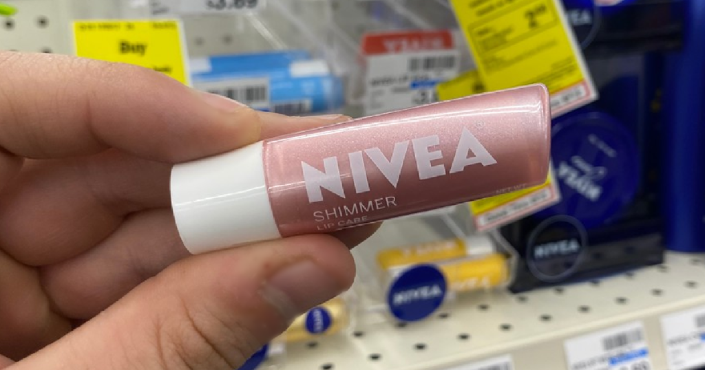 hand holding container of lip care in front of store display