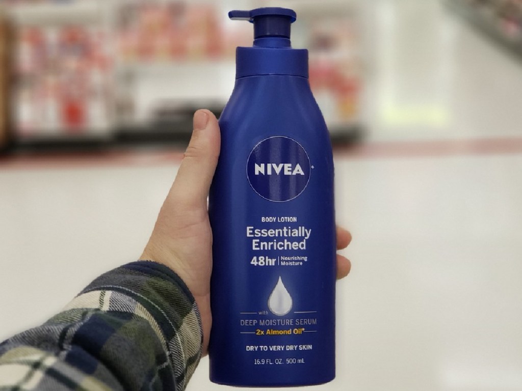 hand holding bottle of Nivea brand lotion in a store