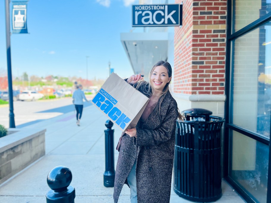 woman holding nordstrom rack shopping bag standing outside