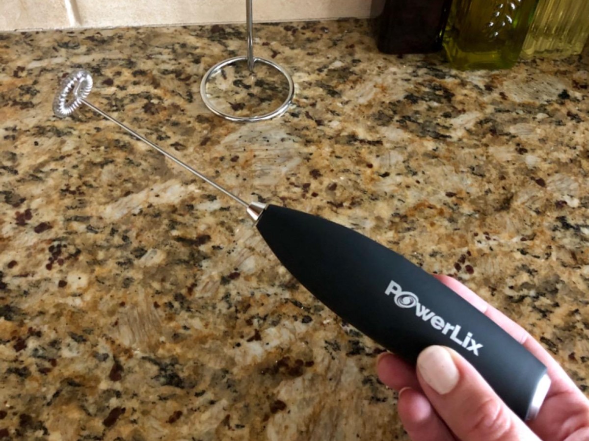 holding a black PowerLix milk frother
