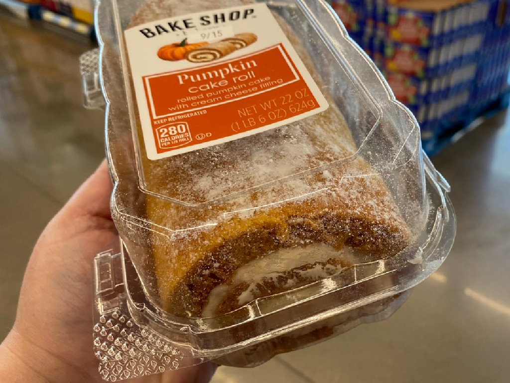 hand holding cake with frosting rolled in middle in package