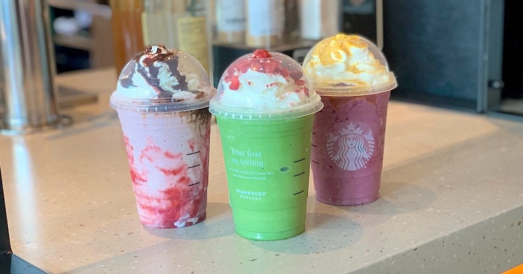 three colorful sanderson sisters frappuccinos on starbucks counter