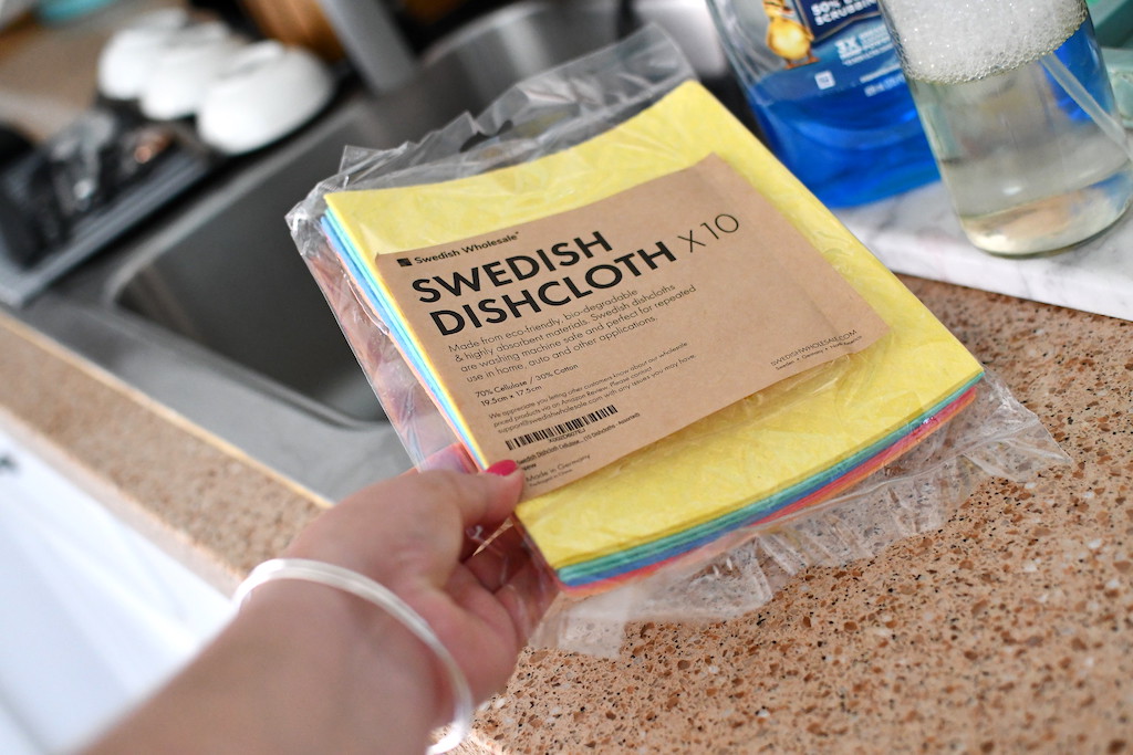 يد تحمل علبة من مناشف الأطباق السويدية