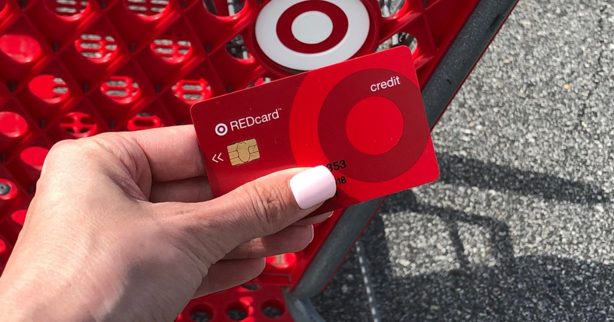 woman's hand holding a target red card above a target shopping cart