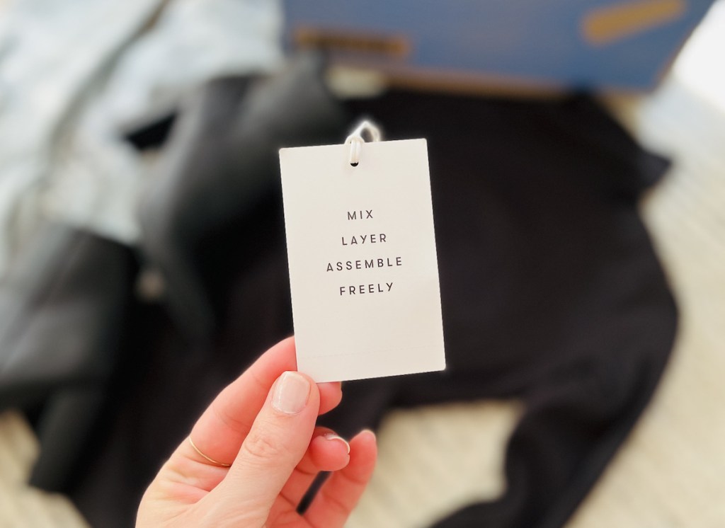 hand holding a free assembly clothing tag
