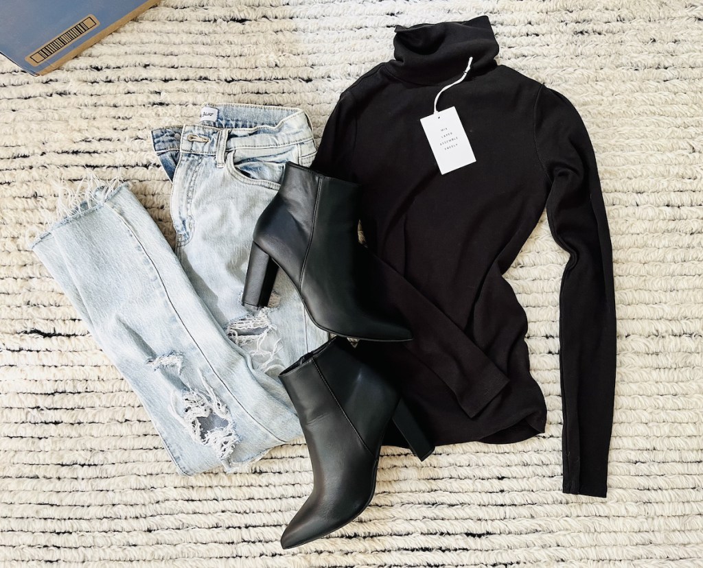 flatlay with light wash jeans black turtleneck and booties