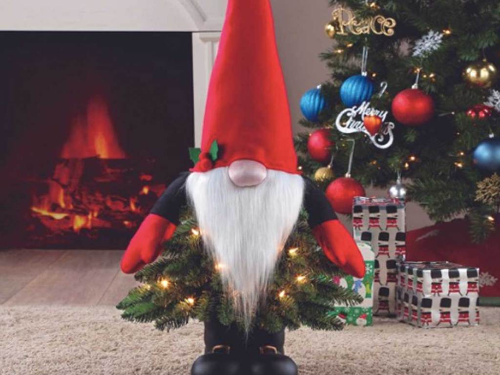 chrismtas gnome standing in front of christmas tree