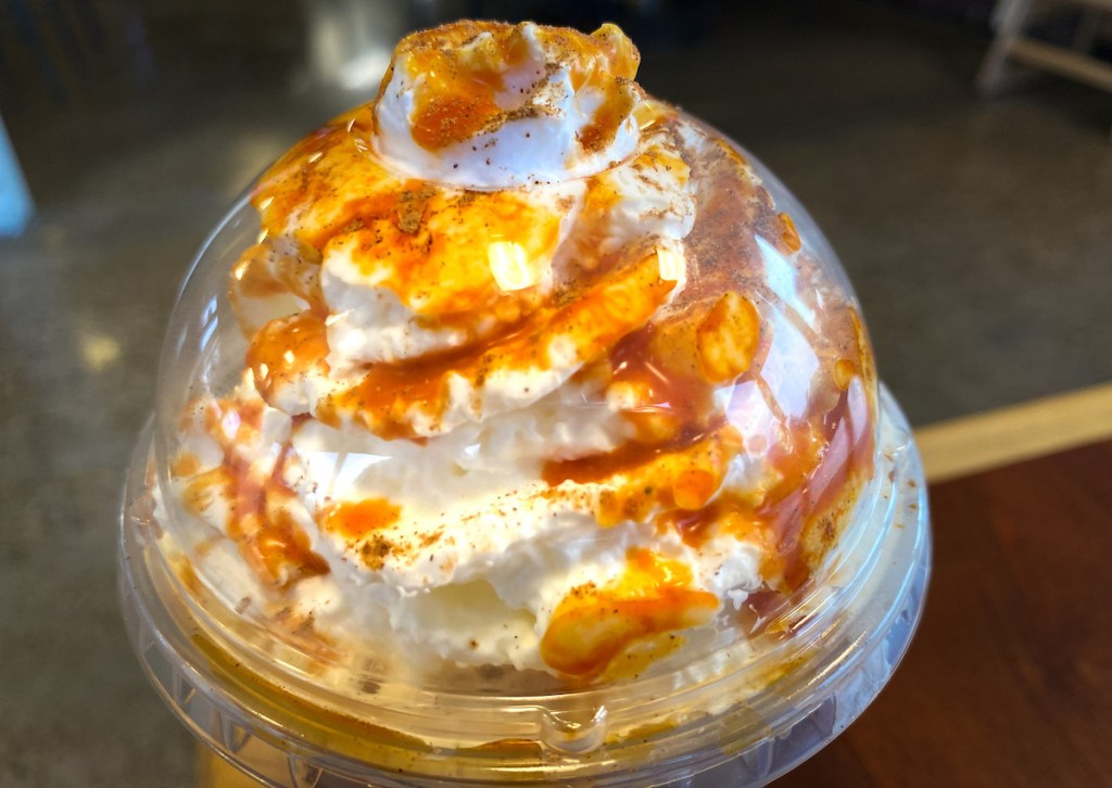 close up of whipped cream with pumpkin sauce drizzle