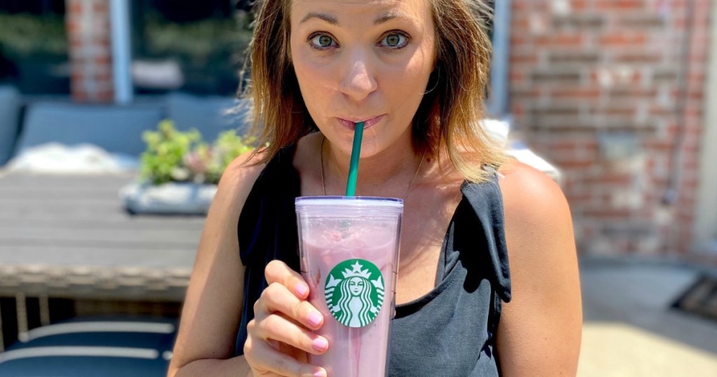 woman sipping from clear starbucks cup