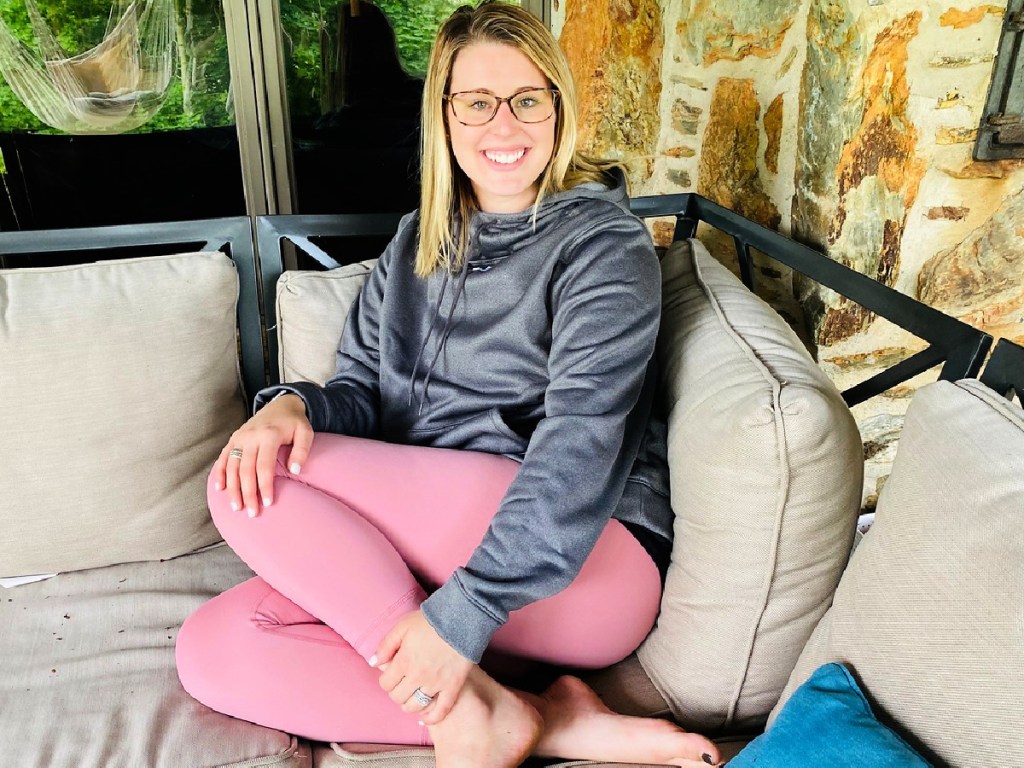 woman on couch wearing under armour storm fleece hoodie