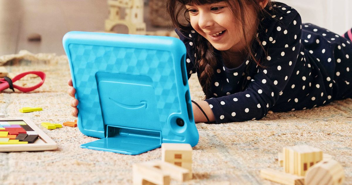girl laying on floor playing with an amazon fire kits tablet with blue case