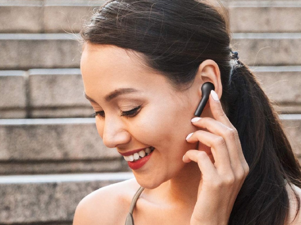 woman wearing black wireless earbuds outside