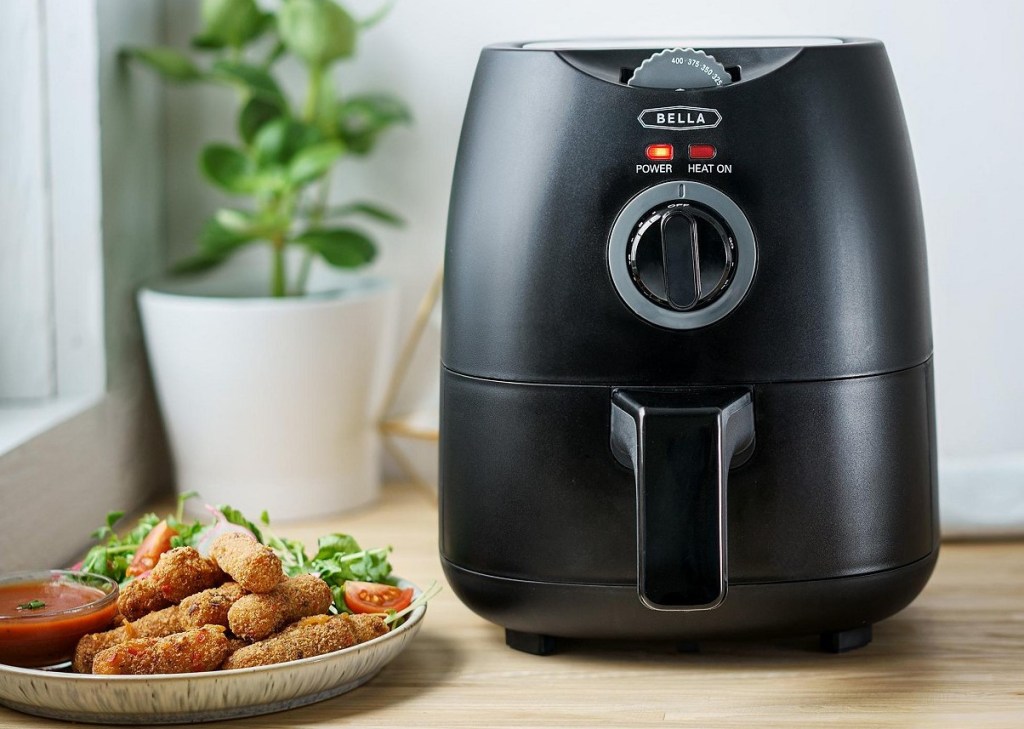 Bella air fryer with plate of food next to it