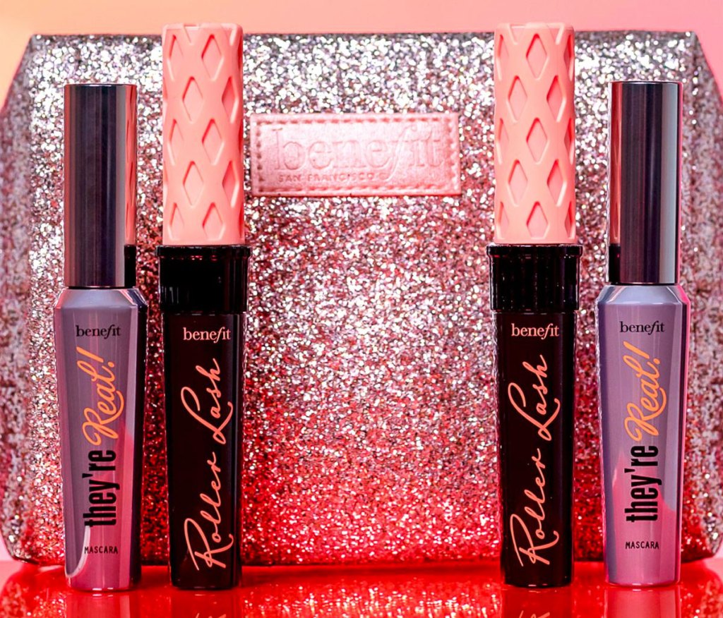 two benefit they're real and two roller ball mascara tubes in front of pink sparkly makeup bag