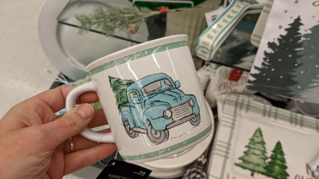 hand holding a mug with a truck on it