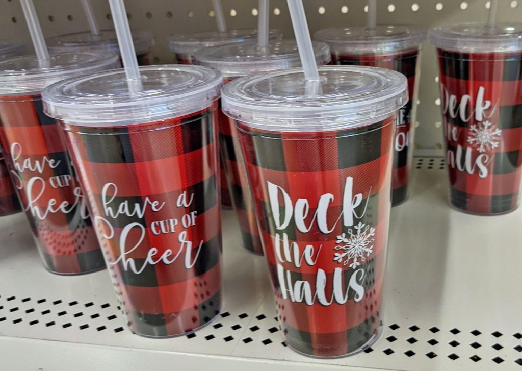 red and black bufflo check drink tumblers with holiday sayings on shelf at dollar tree