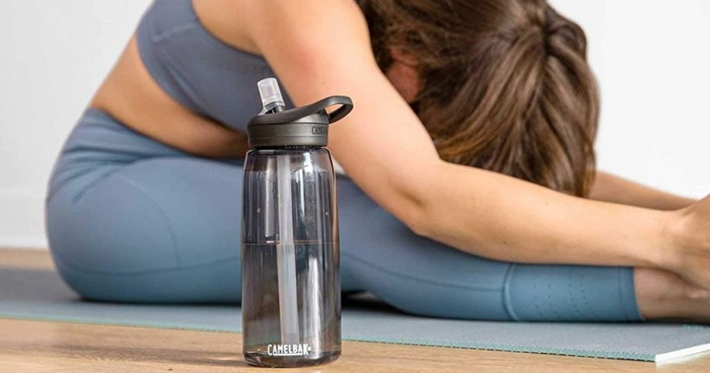 Woman doing joga next to CamelBack water bottle