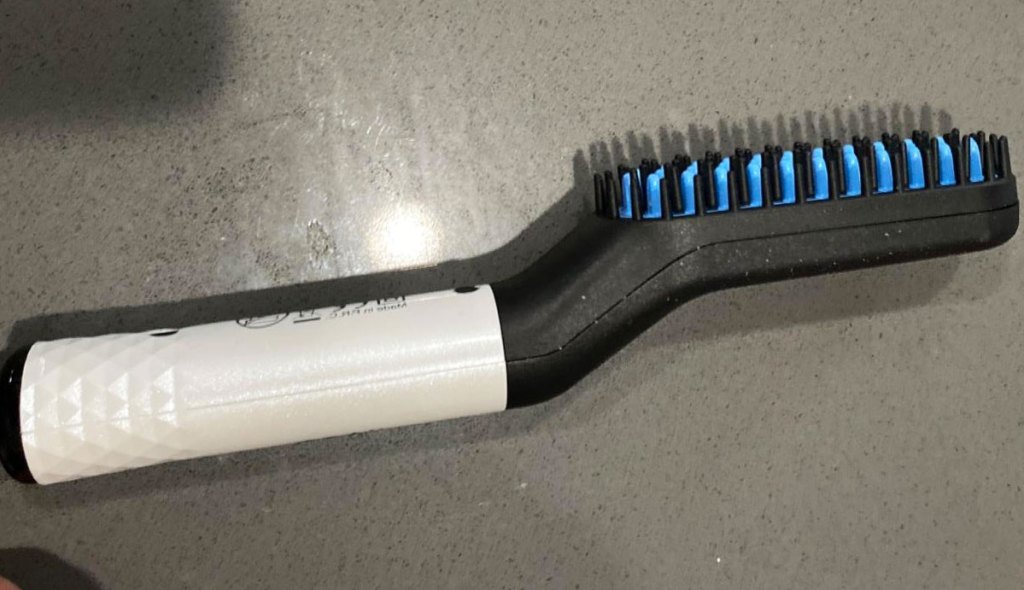 white and black beard straightening comb on bathroom counter