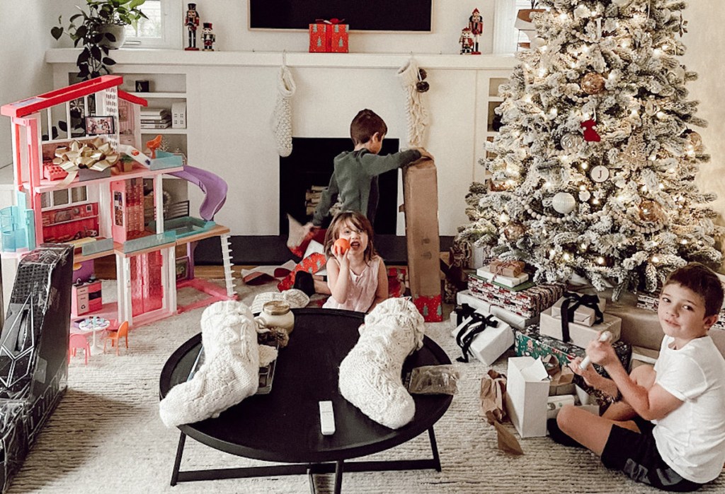 kids in living room on christmas morning opening gifts
