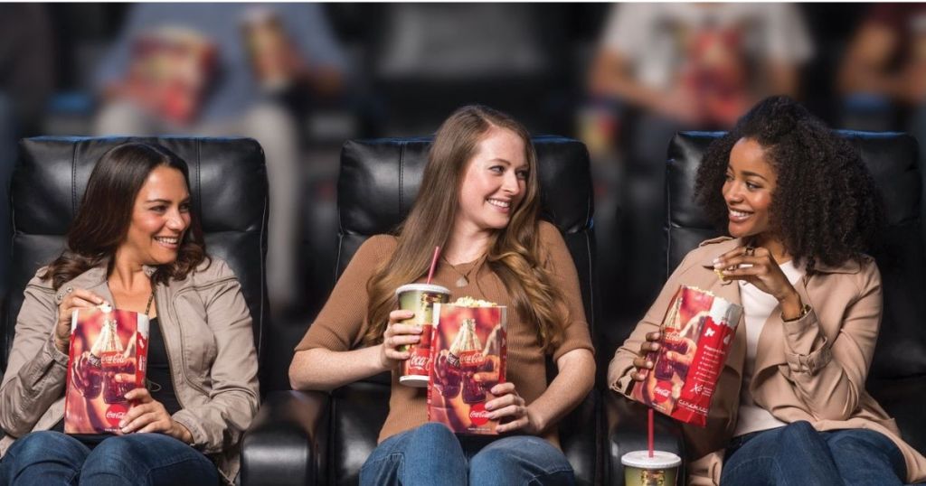 women sitting in theater with popcorn