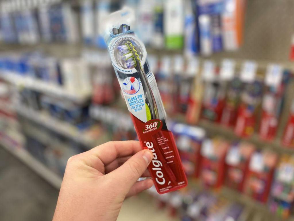 hand holding a Colgate toothbrush